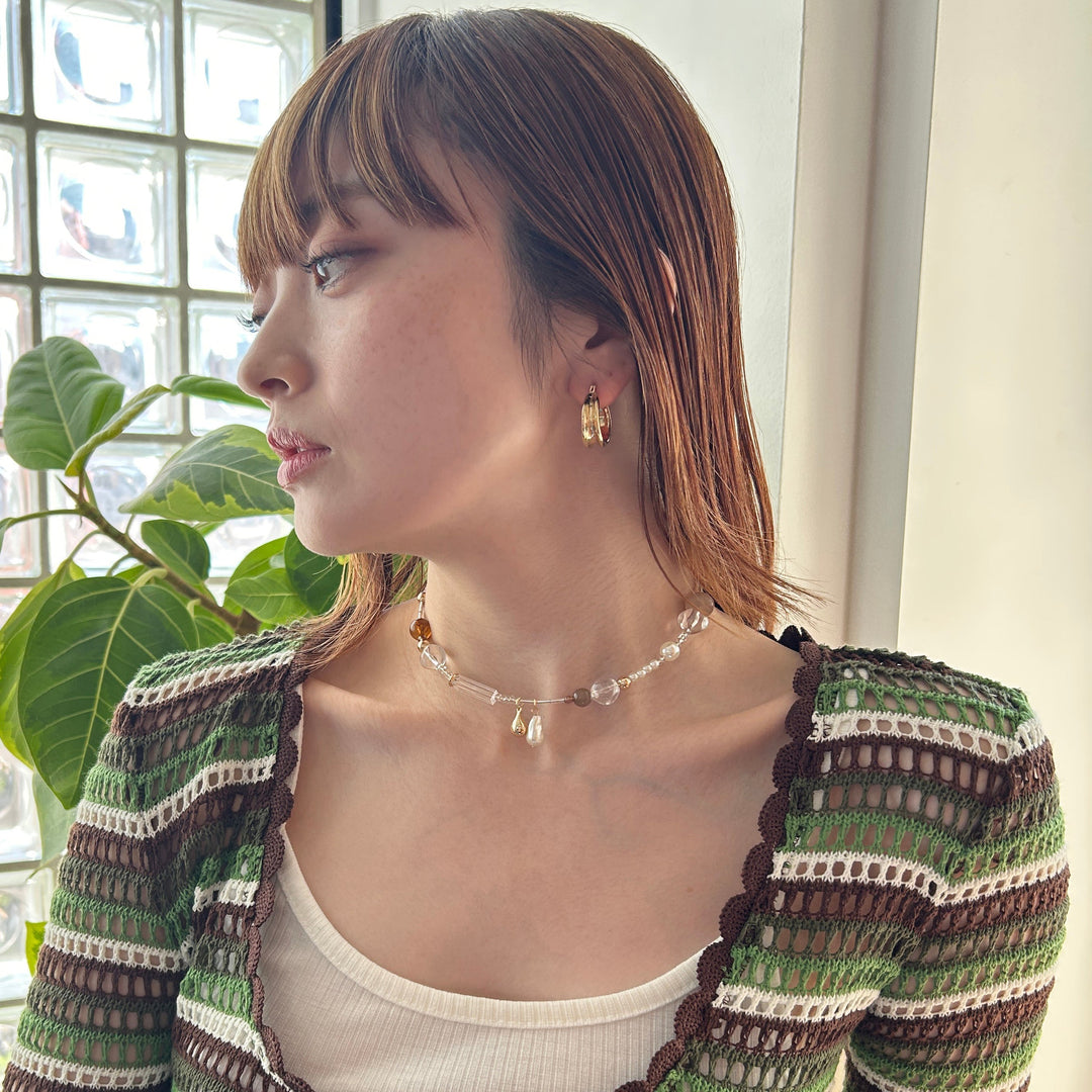 落ち着いたカラーのビーズネックカフは秋コーデとの相性◎